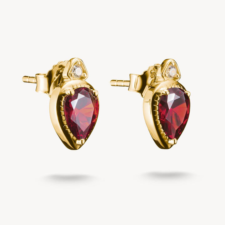 Gold earrings with red gemstones on a white background
