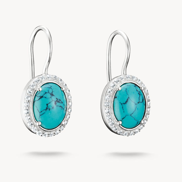 Turquoise earrings with silver hooks on a white background