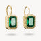 Gold earrings with green gemstones on a white background