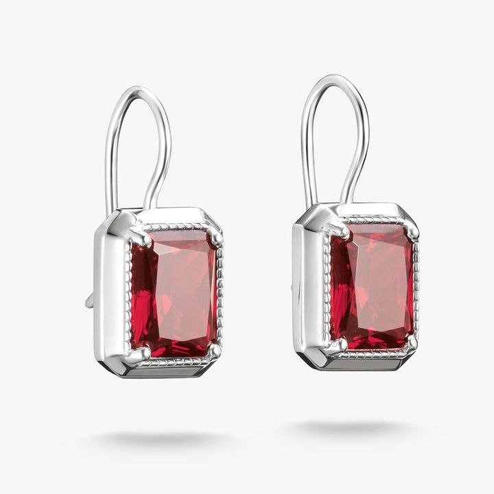 Pair of earrings with red gemstones on a white background