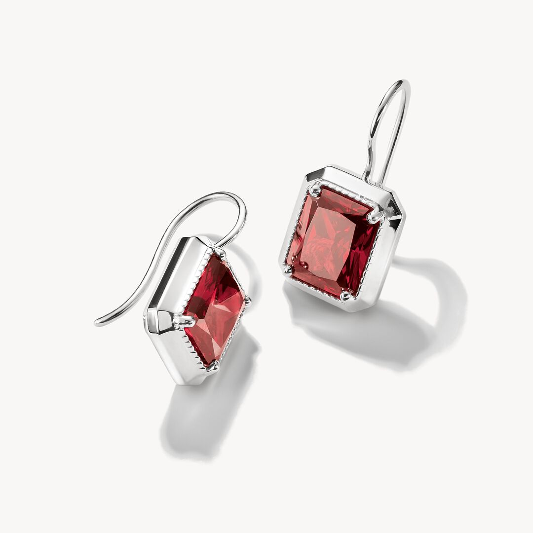 Pair of earrings with red gemstones on a white background
