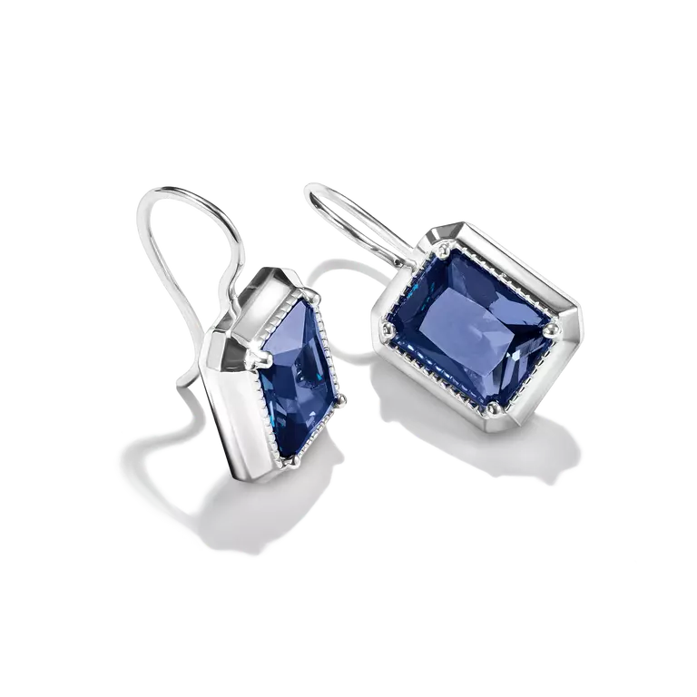 A pair of silver drop earrings featuring rectangular blue gemstones in a bezel setting with a delicate border, shown against a plain white background.