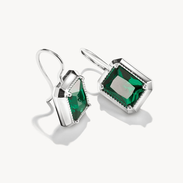 Pair of silver earrings with green gemstones on a white background