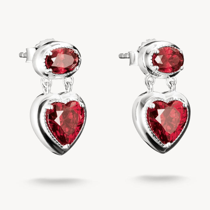 Silver earrings with red heart-shaped gemstones on a white background