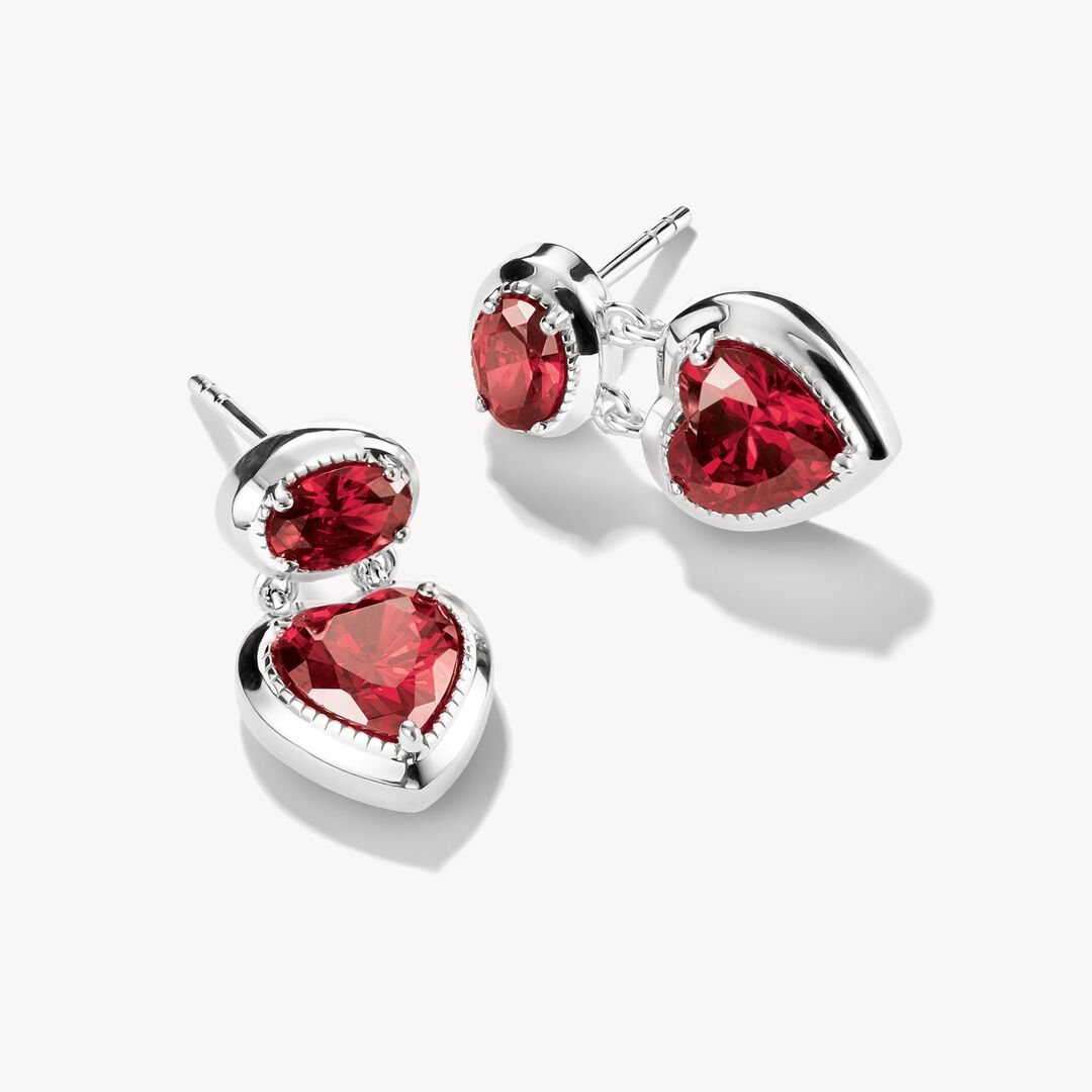 Silver earrings with red gemstones on a white background