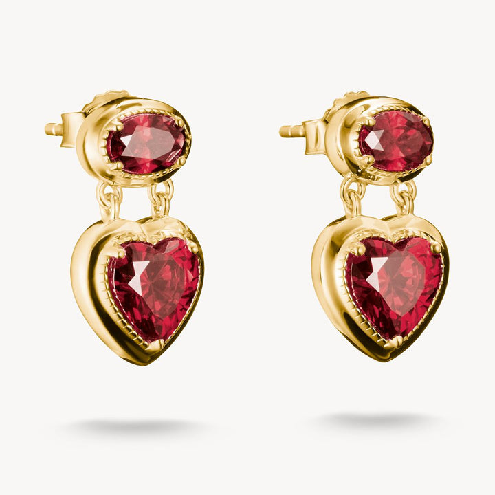 Gold earrings with red heart-shaped gemstones on a white background