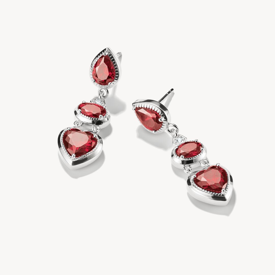 Pair of earrings with red gemstones on a white background