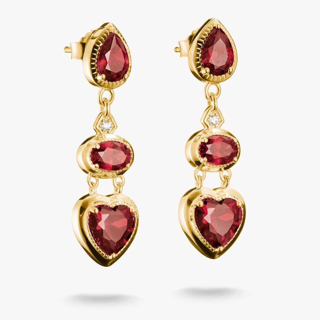 Gold earrings with red gemstones on a white background
