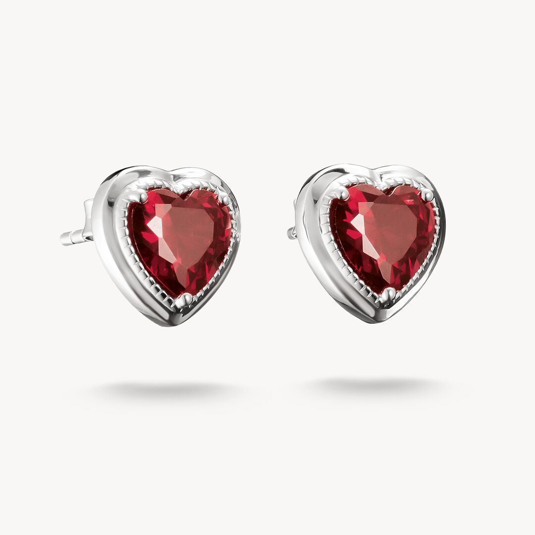 Heart-shaped earrings with red gemstones on a white background