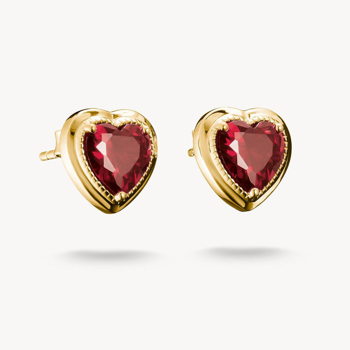 Heart-shaped earrings with red gemstones and gold frames on a white background