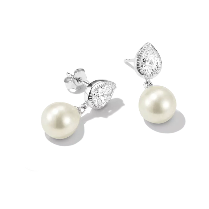 A pair of silver drop earrings featuring pear-cut clear stones and round white freshwater pearls, displayed on a clean white background.