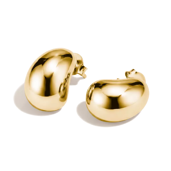 A pair of polished gold bean-shaped stud earrings on a clean white background.