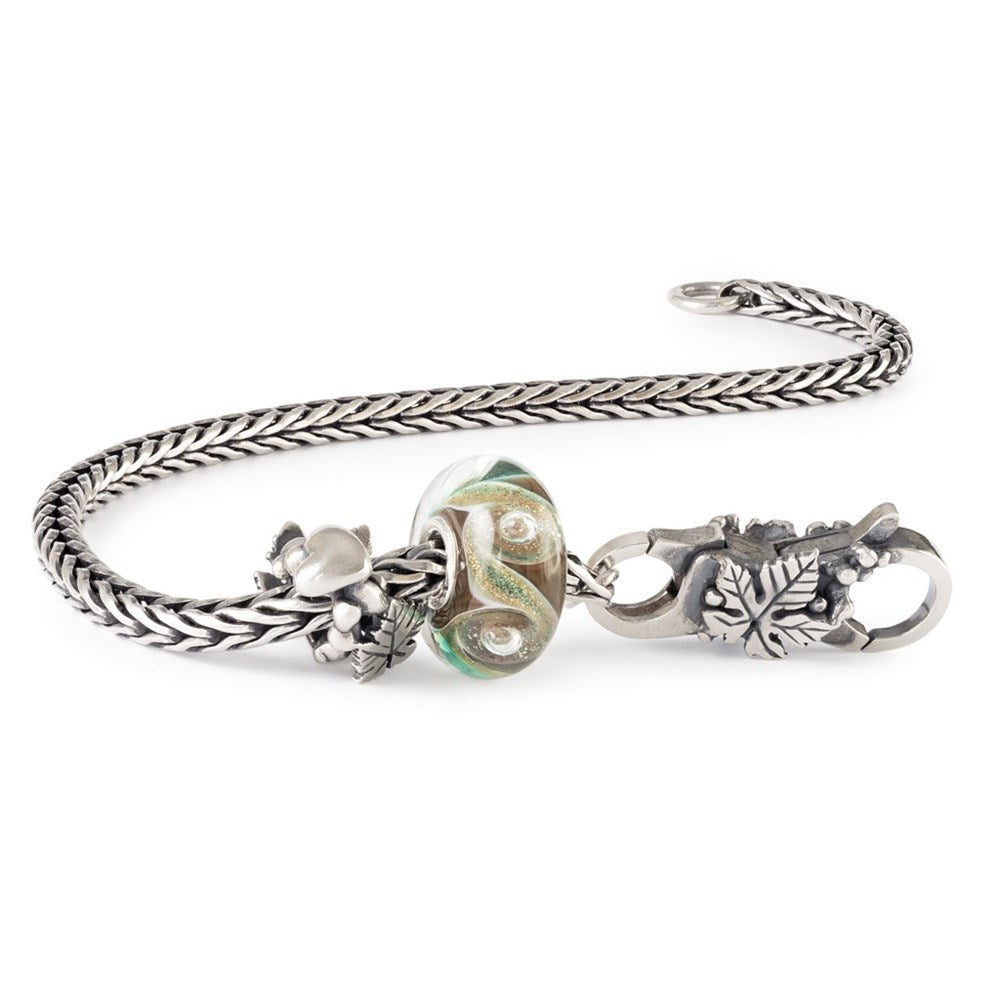 Silver bracelet with leaf and floral designs on a white background