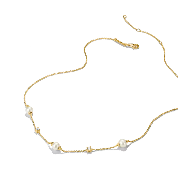 A delicate gold chain necklace featuring small white pearls and tiny clear crystal accents, displayed on a clean white background.