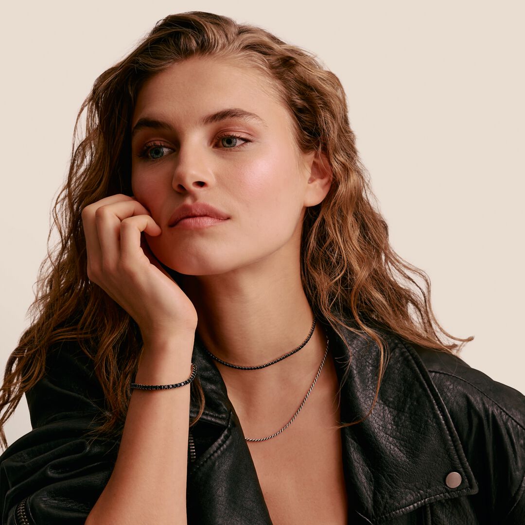 Woman wearing a black leather jacket with a neutral background