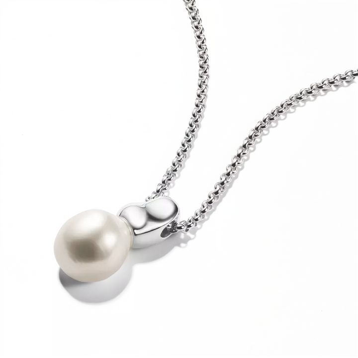 A silver chain necklace with a polished silver heart-shaped pendant holding a single lustrous white pearl, shown on a clean white background.