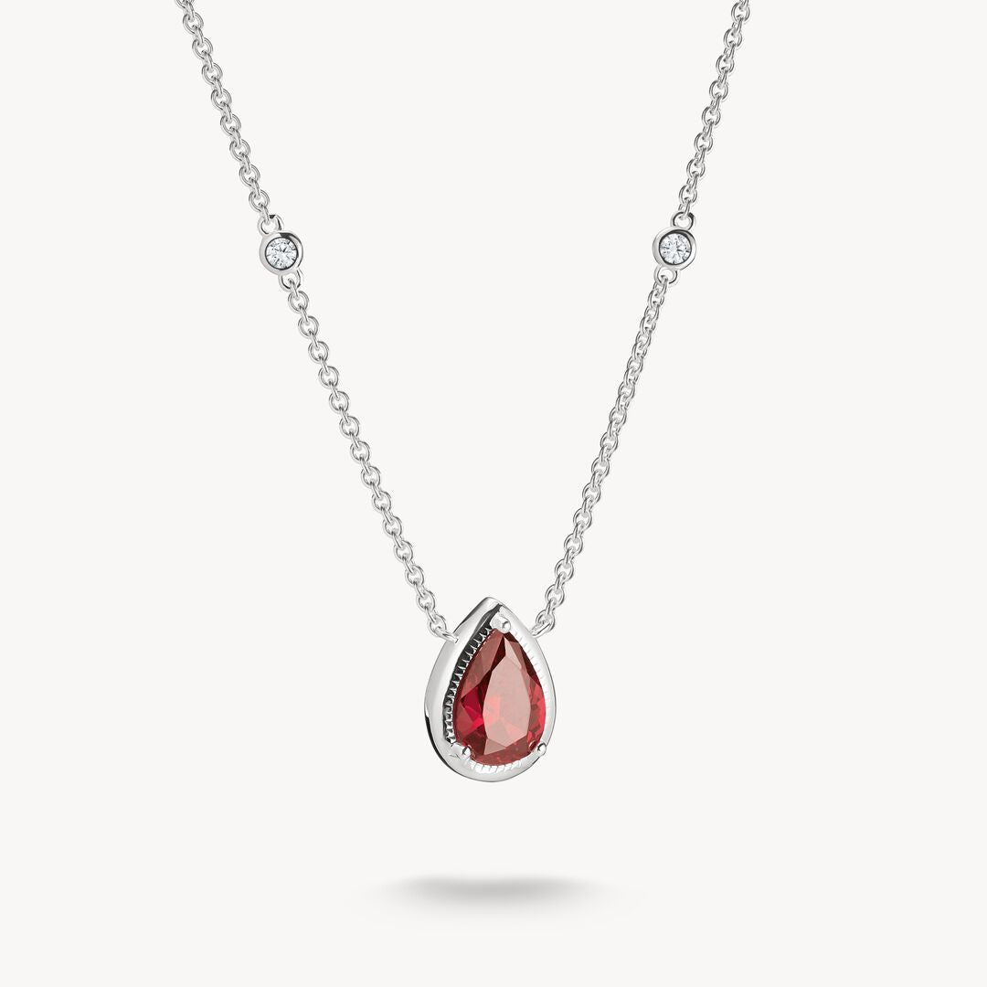 Silver necklace with a red teardrop pendant on a white background