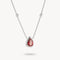 Silver necklace with a red teardrop pendant on a white background