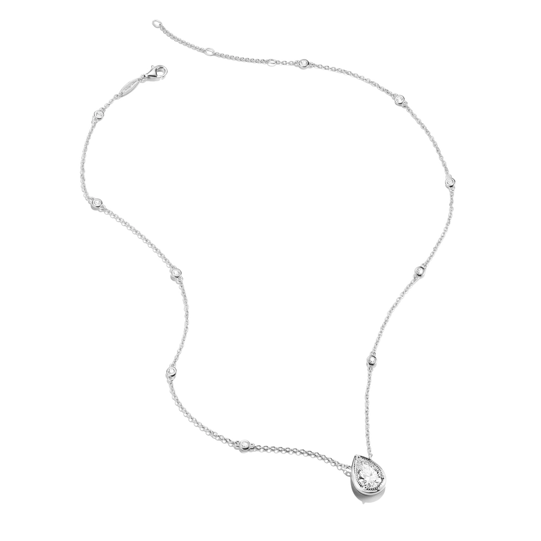 A delicate silver-toned necklace featuring a teardrop-shaped pendant set with a clear gemstone, accented by small bead details along the chain, shown on a plain white background.