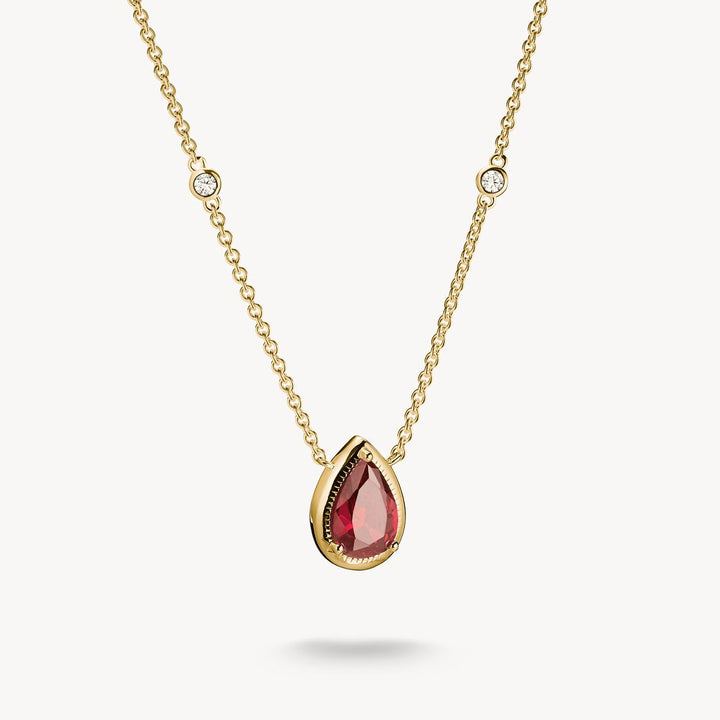 Gold necklace with a red teardrop pendant on a white background