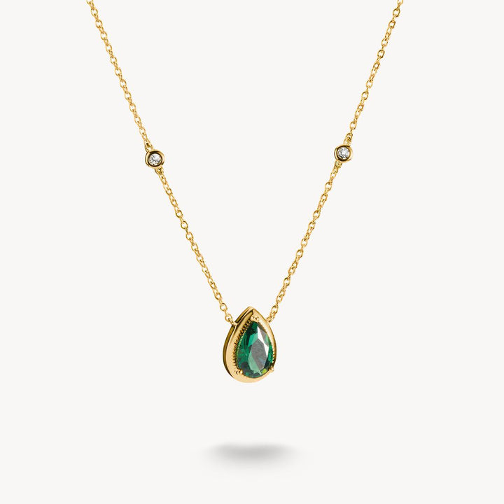 Gold necklace with a green teardrop pendant on a white background