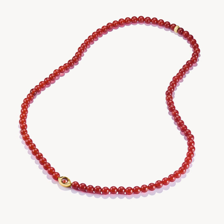 Red beaded necklace with a gold clasp on a white background