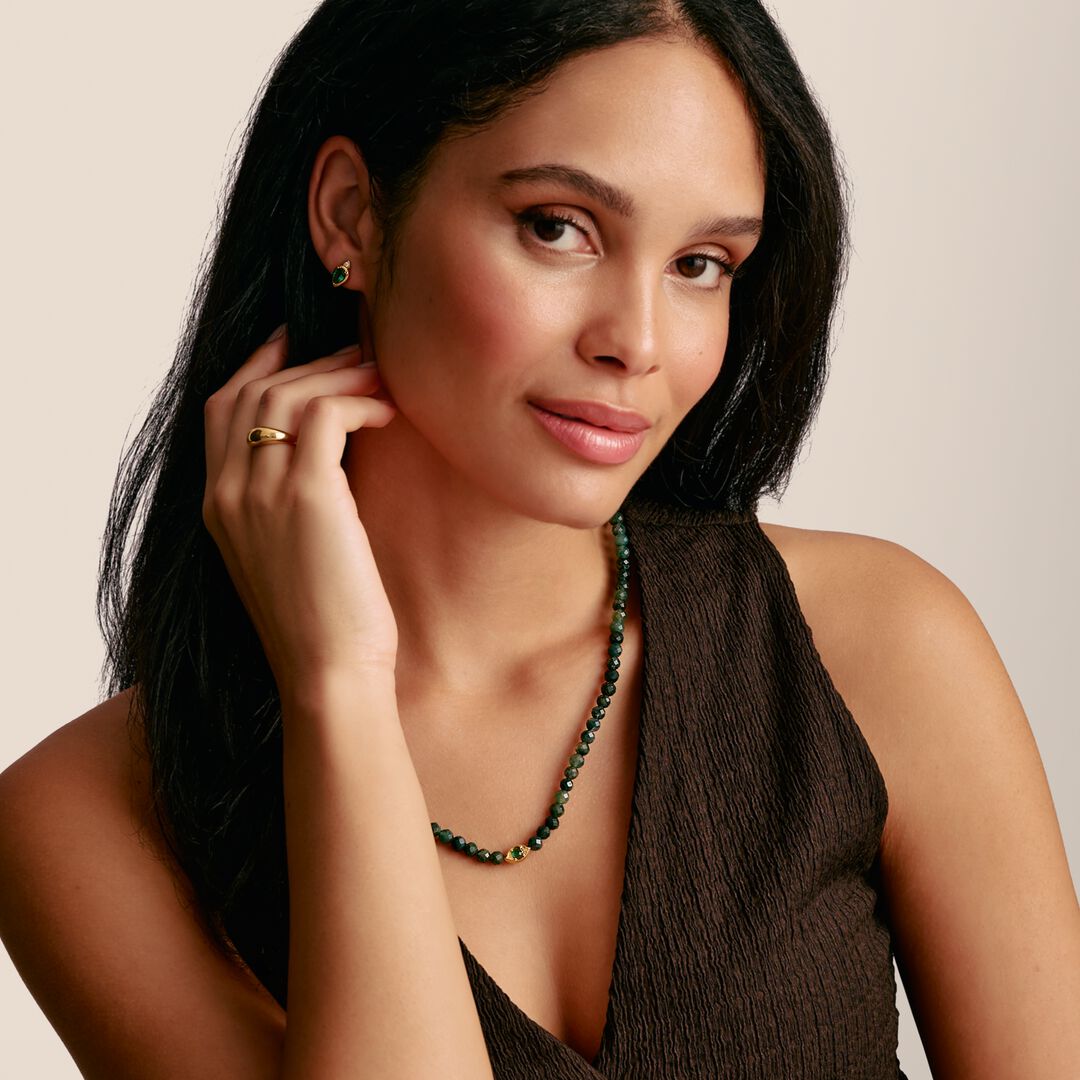 Woman wearing a necklace with a neutral background