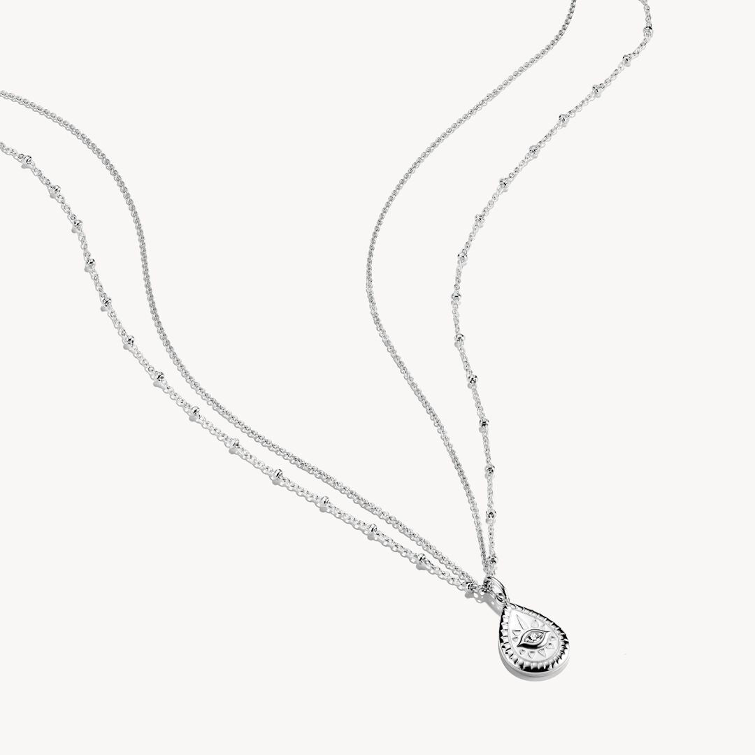 Silver necklace with a teardrop pendant on a white background