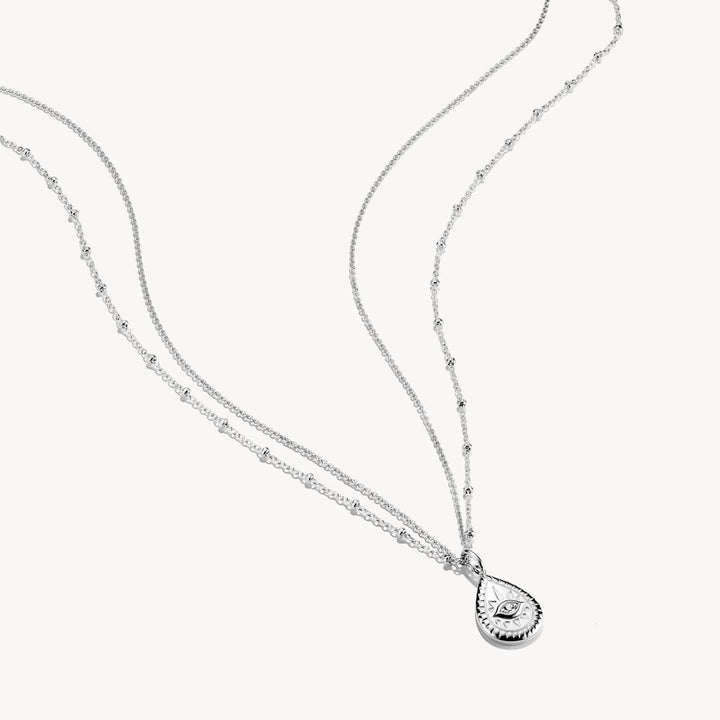 Silver necklace with a teardrop pendant on a white background