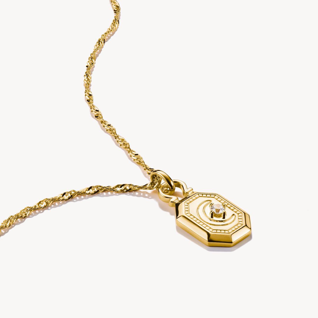 Gold necklace with a hexagonal pendant on a white background