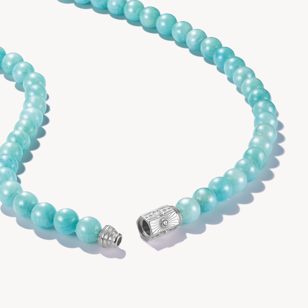 Turquoise beaded necklace with a silver clasp on a white background