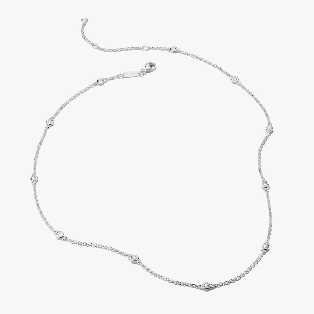 Silver necklace with small diamonds on a white background