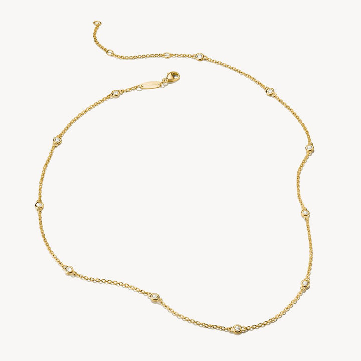Gold necklace with small beads on a white background