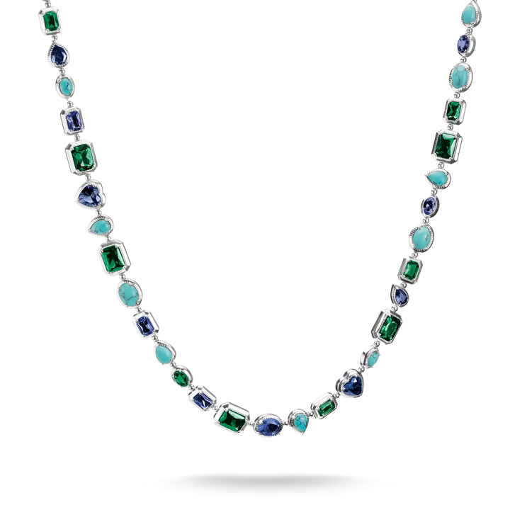 A silver-toned necklace featuring a series of colorful gemstones, including emerald-cut green, oval blue, round turquoise, and marquise-cut light blue stones, displayed against a clean white background.
