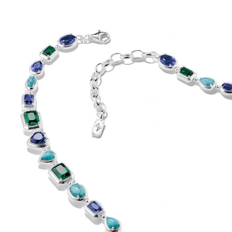 A sterling silver bracelet featuring a variety of colored gemstones, including emerald-cut green, marquise-cut turquoise, round blue, and oval purple stones, displayed on a clean white background.