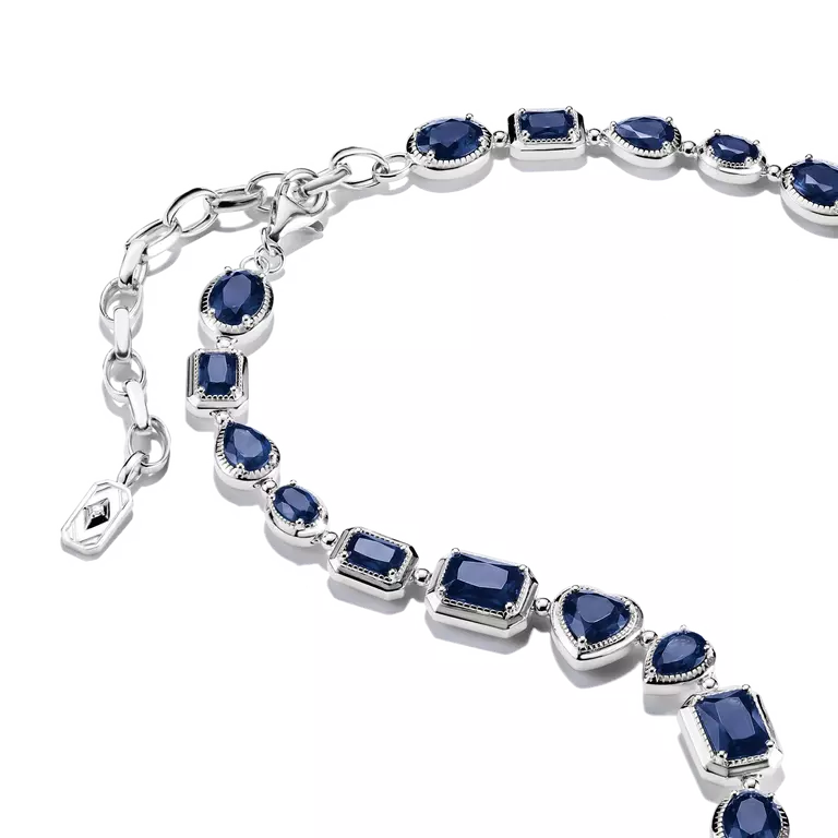 A silver-toned bracelet featuring multiple oval and rectangular dark blue gemstones in bezel settings, displayed on a clean white background.