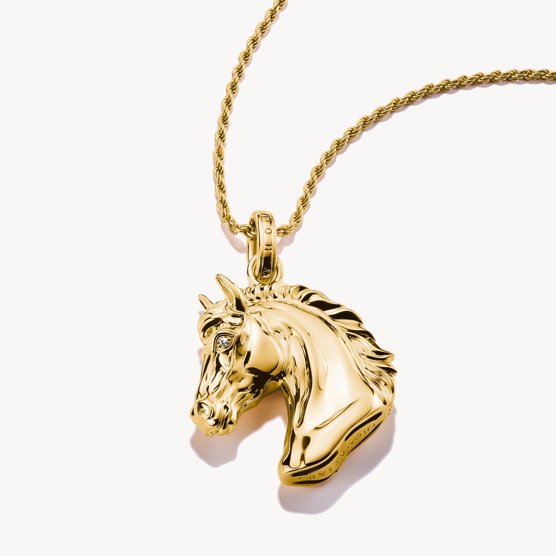 Gold horse head pendant on a gold chain against a white background