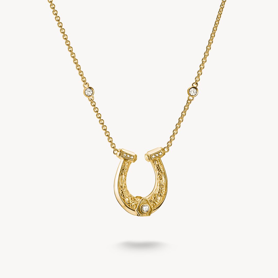 Gold horseshoe necklace with small diamonds on a white background
