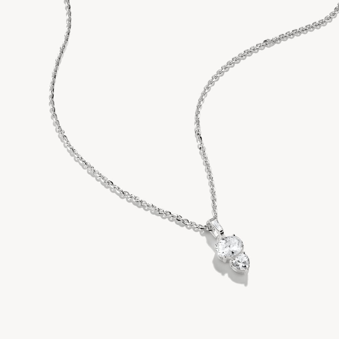 Silver necklace with a heart-shaped pendant on a white background