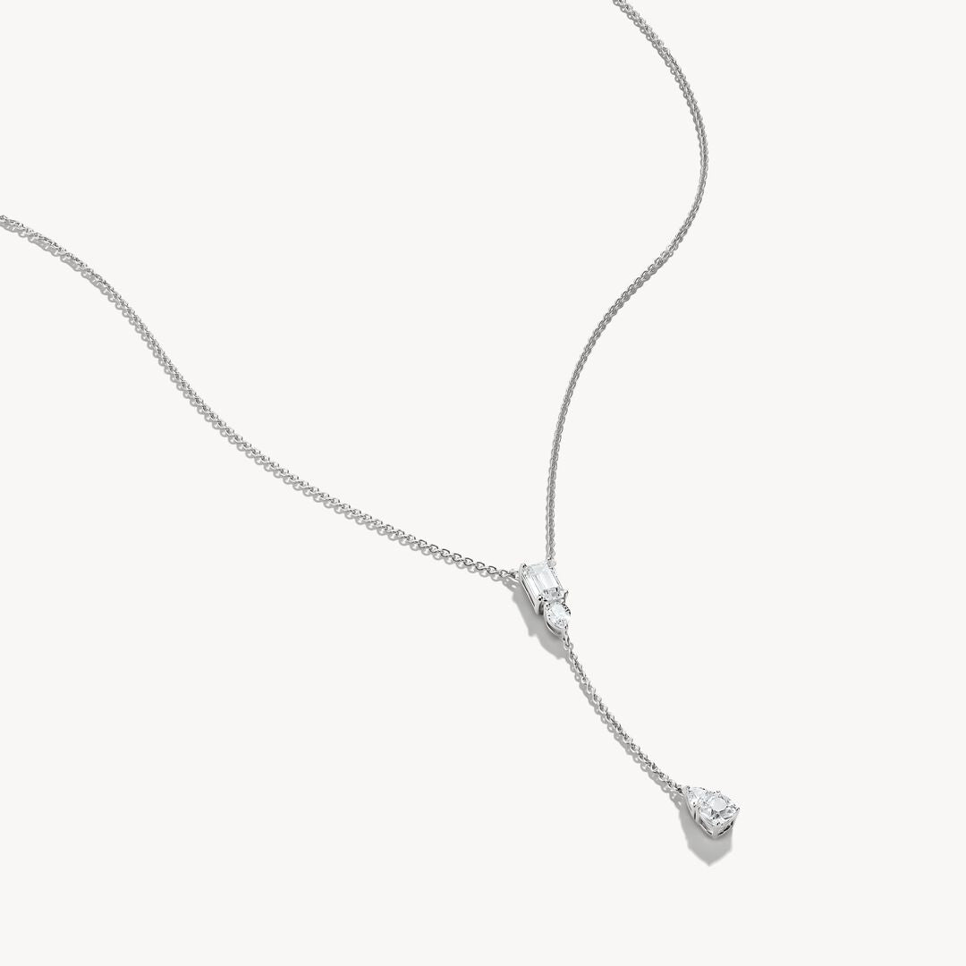 Silver necklace with a heart-shaped pendant on a white background