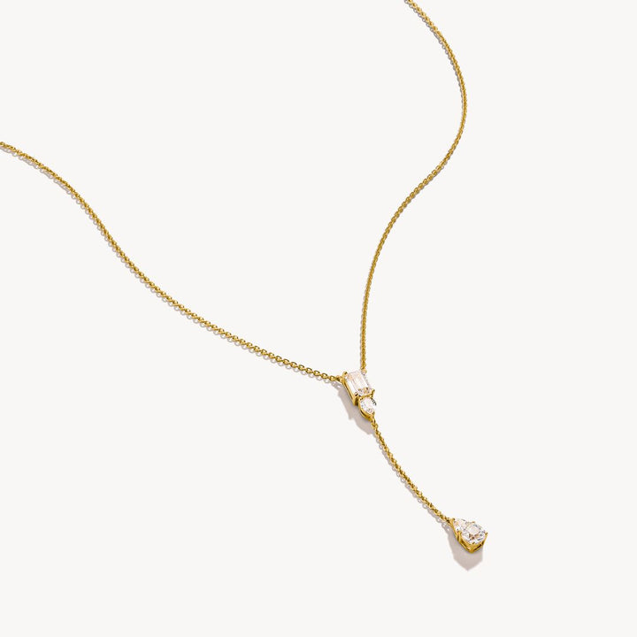 Gold necklace with a small pendant on a white background