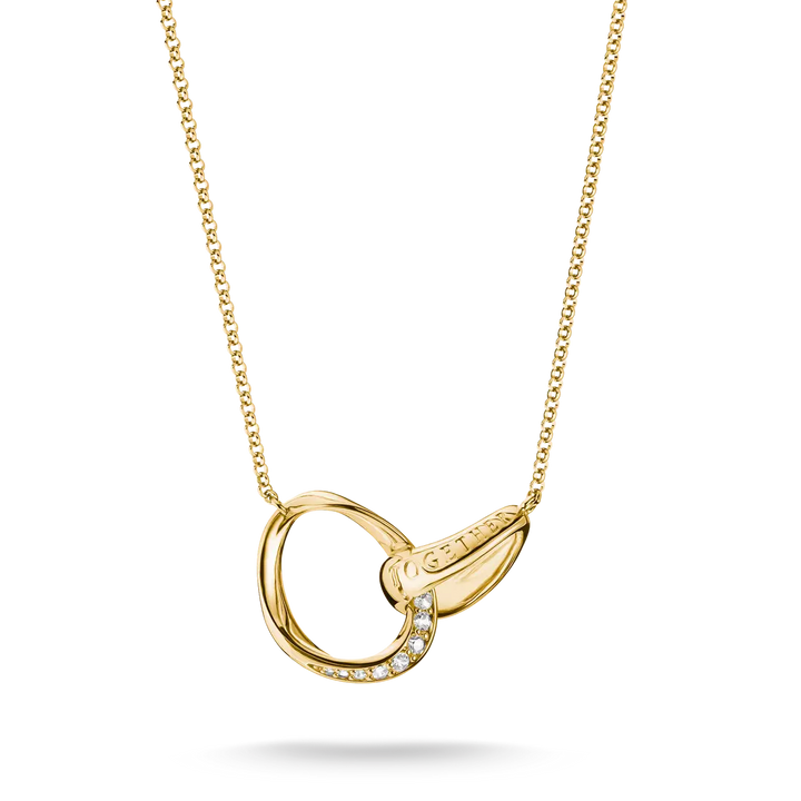 A gold necklace featuring an open interlocking ring pendant with a small row of clear stones on one side and a teardrop-shaped gold element on the other, shown on a white background.