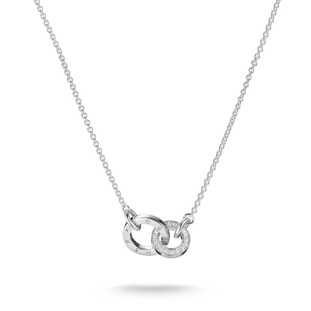 A silver chain necklace featuring two interlocking circular pendant elements, one with engraved Roman numerals and the other set with small clear stones, shown on a white background.