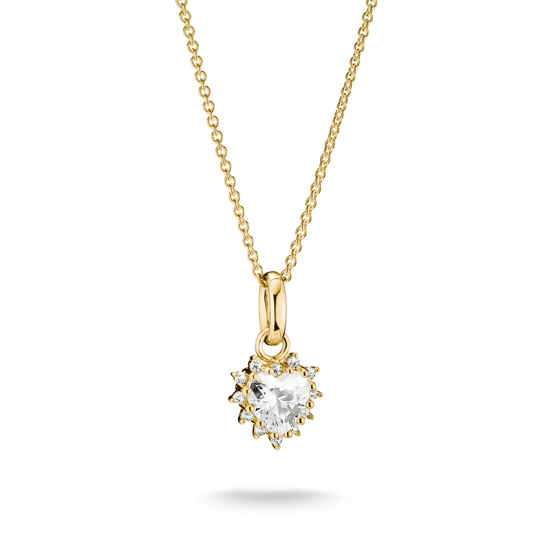 A yellow gold necklace with a heart-shaped clear gemstone pendant in a prong setting, suspended from a delicate gold chain against a white background.