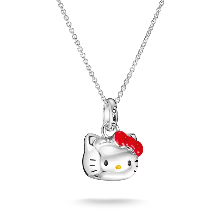 A silver Hello Kitty pendant necklace featuring a polished silver cat head with a bright red bow and small yellow nose, hanging from a delicate silver chain against a white background.
