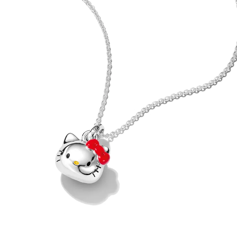 A silver pendant necklace featuring a Hello Kitty face with a red bow and small yellow nose, suspended on a silver chain against a white background.