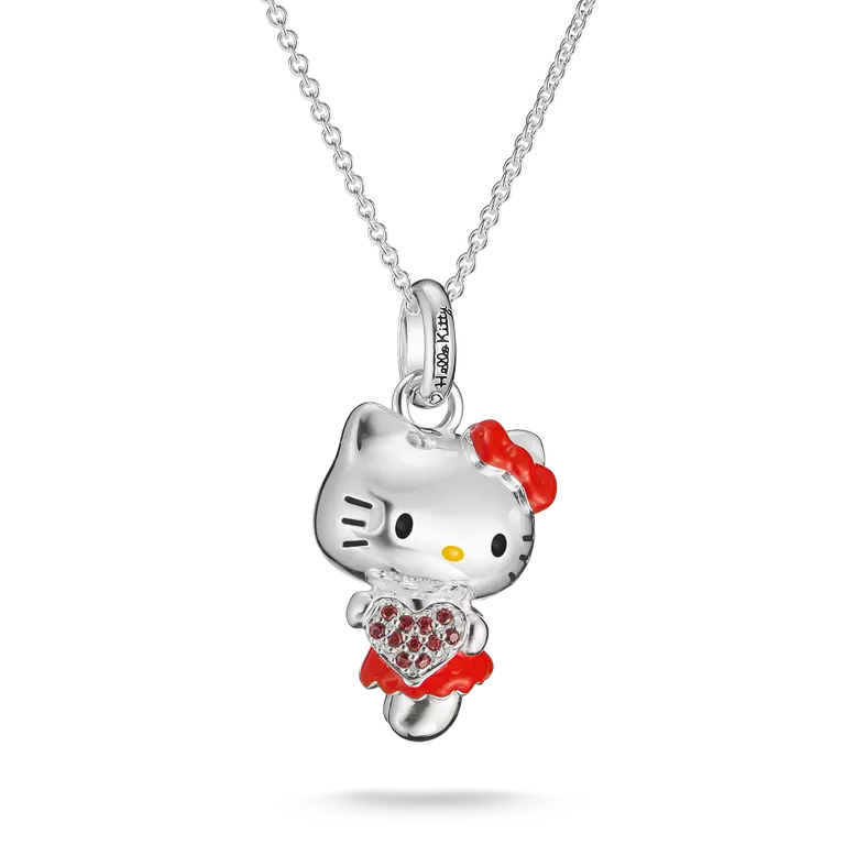 A silver Hello Kitty pendant necklace featuring a silver Hello Kitty figure with a red bow, red dress, and a red heart-shaped crystal heart, suspended on a silver chain against a white background.