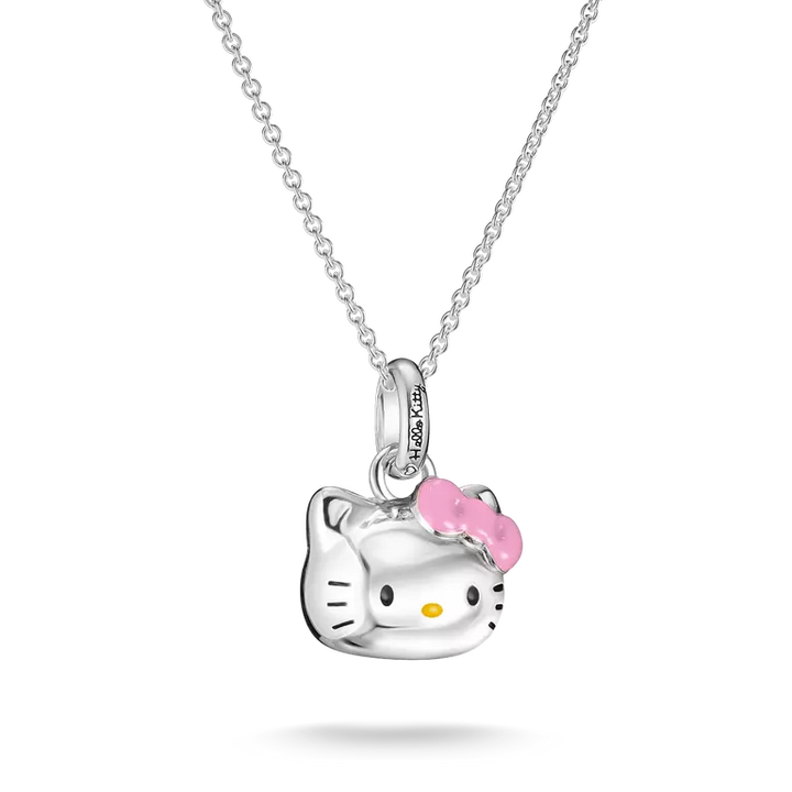 A silver Hello Kitty pendant necklace featuring a polished silver cat head with a pink bow and small yellow nose, suspended from a delicate silver chain against a white background.