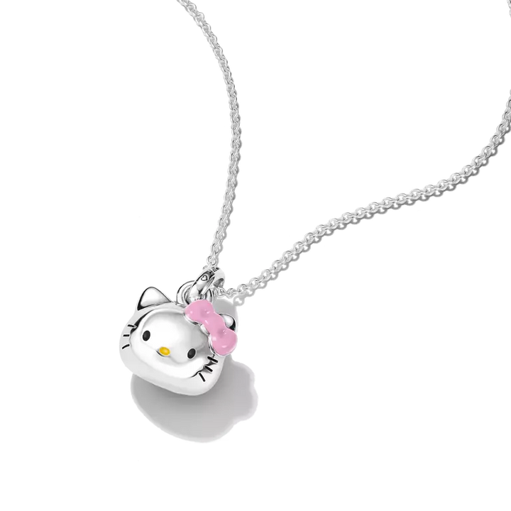 A silver Hello Kitty pendant necklace on a delicate silver chain, featuring a polished silver Hello Kitty face with a pink bow and small yellow accent, set against a clean white background.