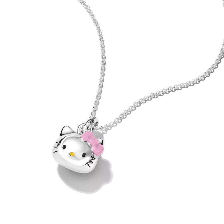 A silver Hello Kitty pendant necklace featuring a polished silver cat head with a pink bow and small yellow nose, suspended from a delicate silver chain against a white background.